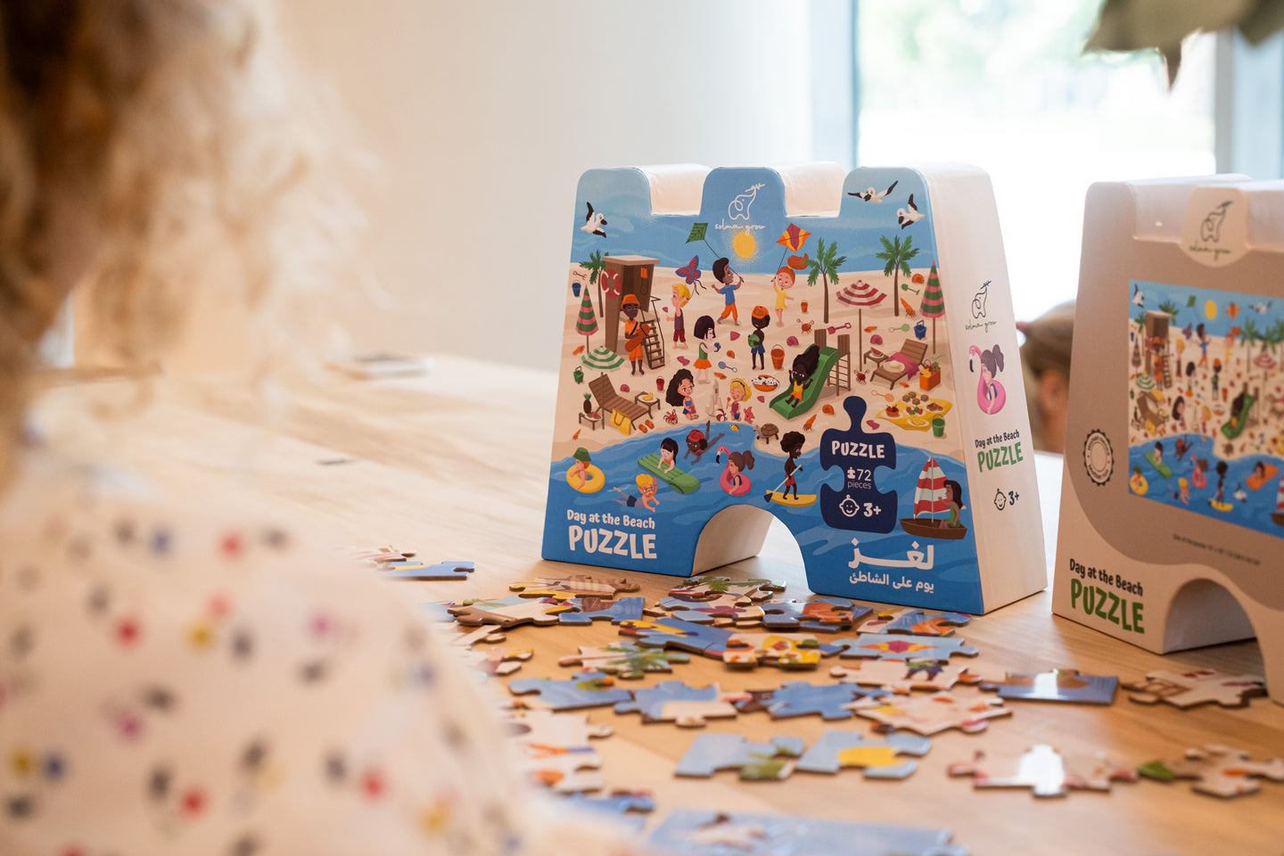 Beach Puzzle box and puzzle on the table with child looking at it